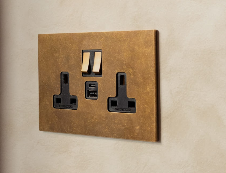 Bronze wall switch and socket on a beige wall