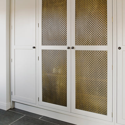 Features our Perforated Interlocking Circle Grille with Fine Mesh Backing in our antique brass unlacquered (ABL) grille finish | Project by Brownlow Furniture.